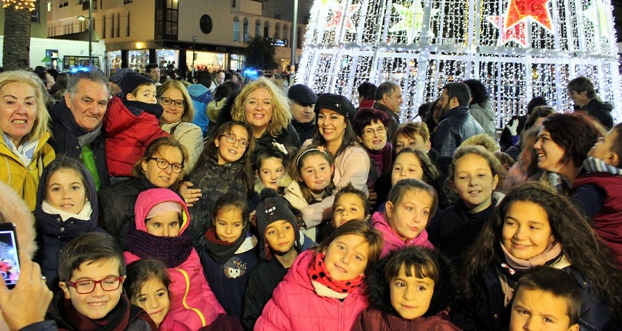 Flor Almón y miembros del equipo de Gobierno con los niños y niñas en el encendido del alumbrado de navidad